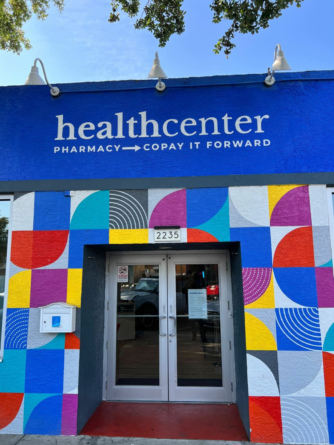 The entrance of the METRO Health Center, highlighted by a vibrant and colorful geometric mural surrounding the doorway.