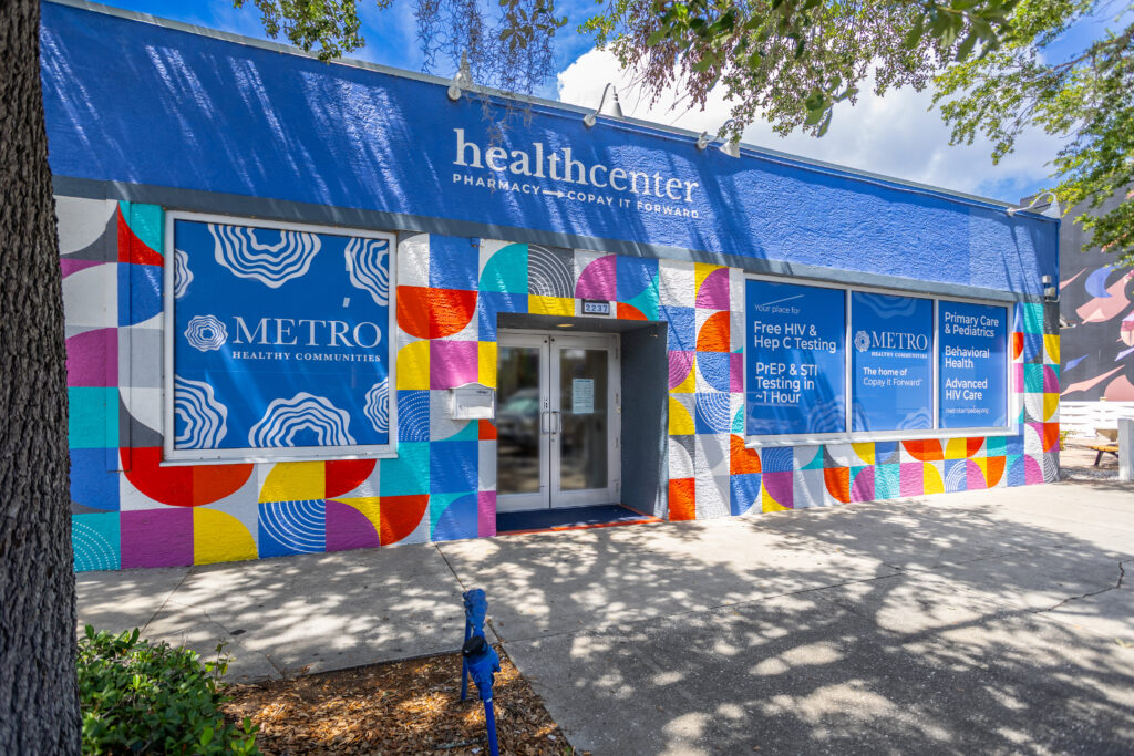 A photo of the exterior of our METRO location on Central Avenue in St. Pete. Sunny day with a bright blue, multi-colored mural on building exterior.