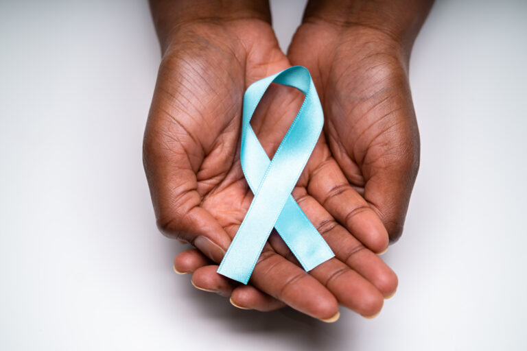 Two open palms gently holding a teal awareness ribbon.